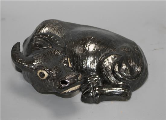 A Chinese black enamelled biscuit porcelain figure of a recumbent ox, probably early 20th century, 25cm